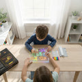 Dos niños dibujando figuras luminosas de colores en la Pizarra LED LumiBoard